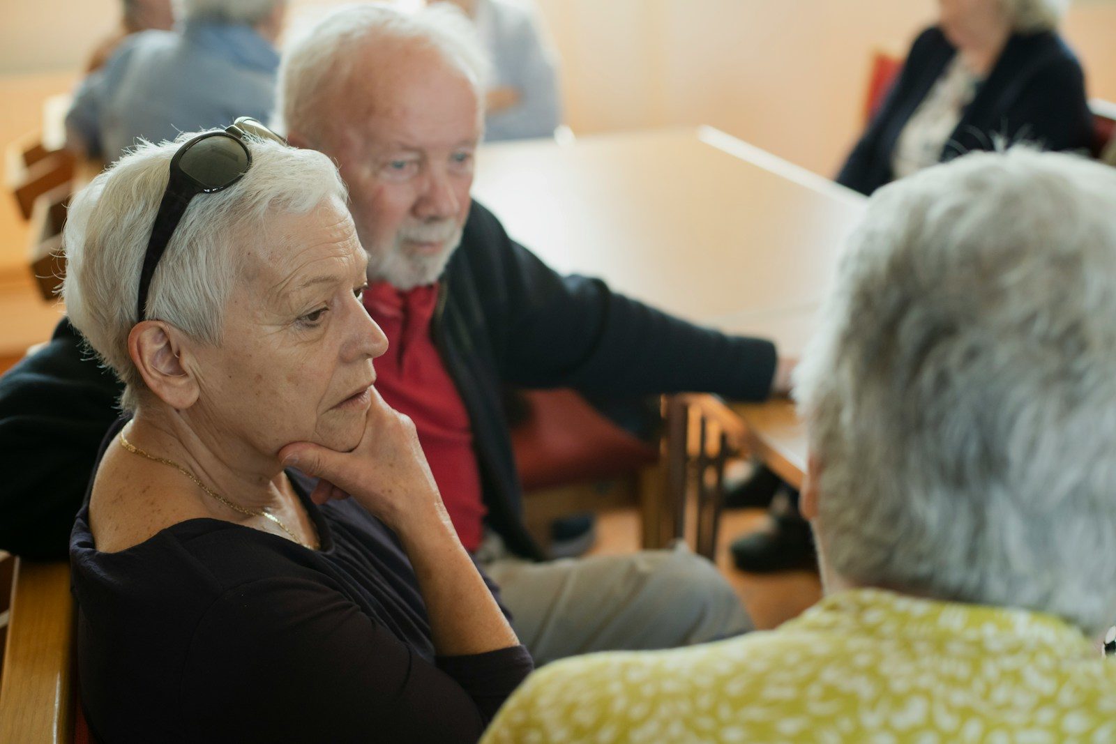 Elderly people are sitting and talking with each other